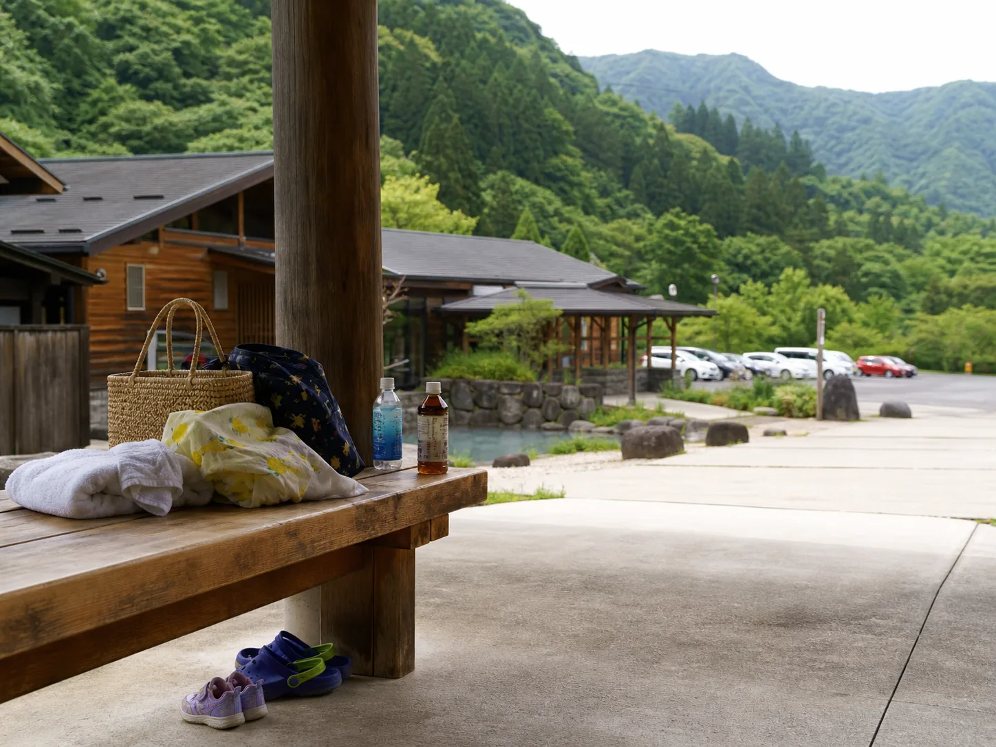 温泉施設前で家族が休憩する写真調イメージ